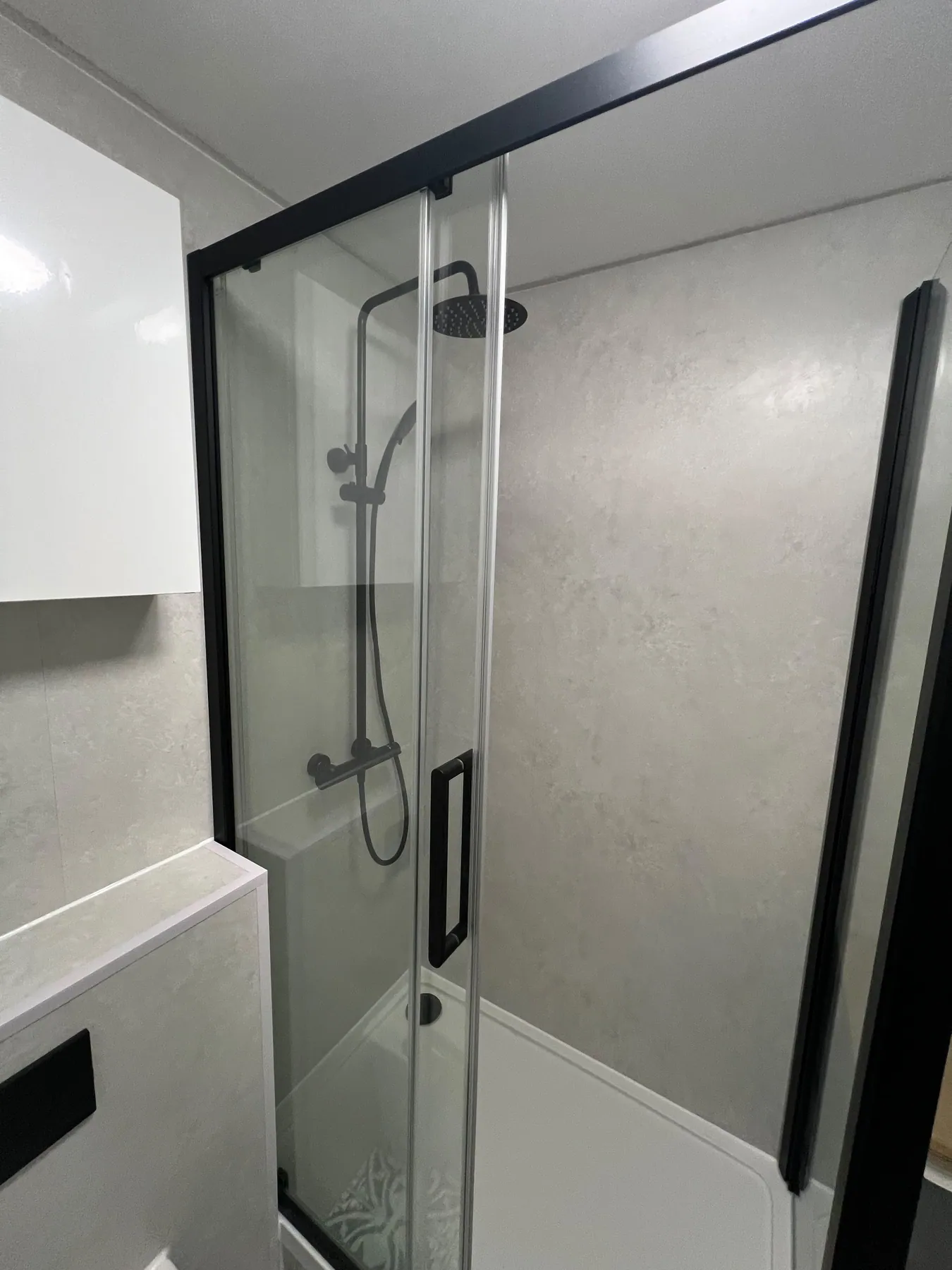 Black-framed shower enclosure with grey wall panels