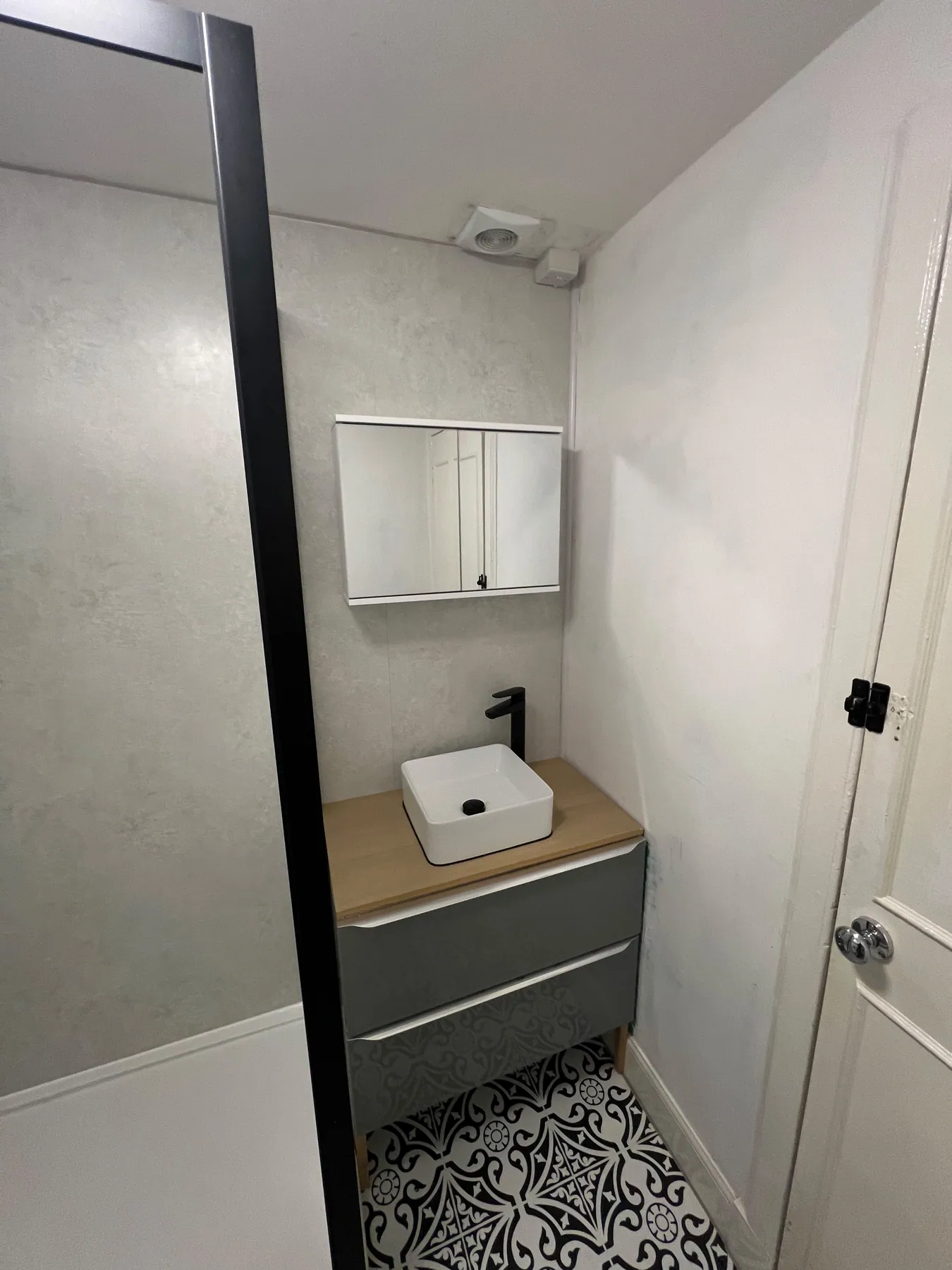 Grey drawer vanity with countertop basin and mirrored cabinet