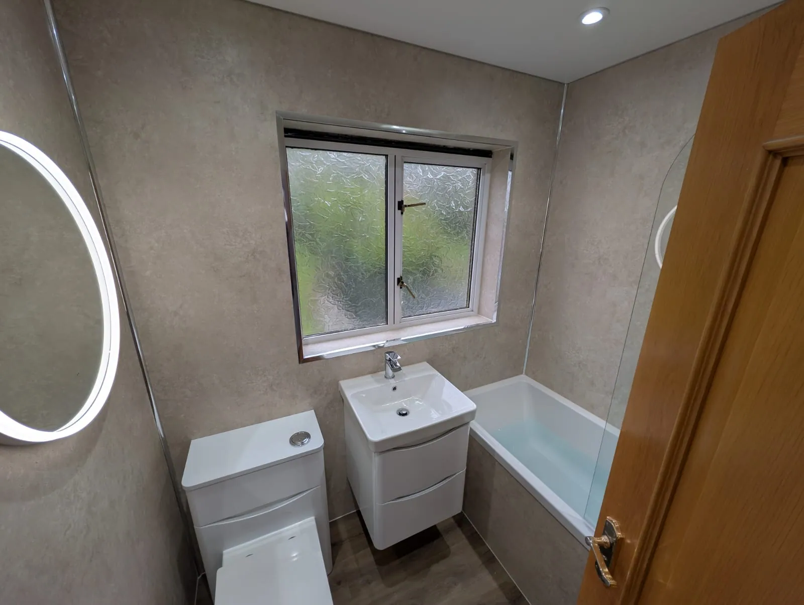 Compact fitted bathroom with white vanity, toilet and bath